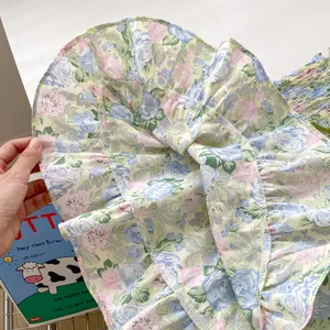 Gros plan détaillé de la robe à fleurs avec volants, coutures blanches et motif rose