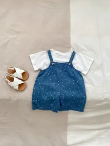 Close-up of baby denim overalls set with cute bear print and soft cotton fabric detail