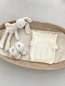 Detalle del chaleco de punto calado para bebé con volantes y zapatos de encaje a juego