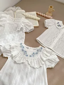 Details von Mädchen-Baumwollshirts mit Blumenstickerei und Spitzenstrukturen