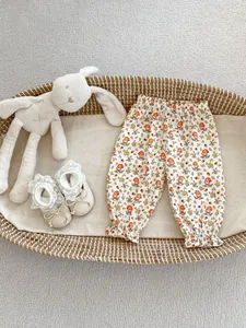 Détail de pantalon floral pour bébé avec taille élastique et revers à volants