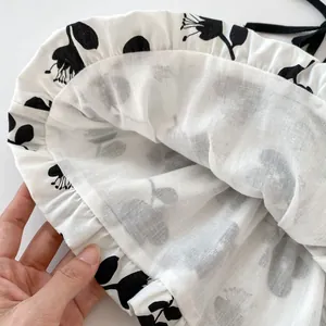 Detail of floral baby girl set featuring black flower prints and delicate ruffle edges
