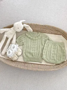 Detailed knit texture of green openwork baby summer set with shorts in a basket