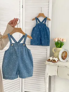 Detail of light blue denim baby overalls featuring cute bear prints and metal buckles