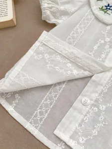 Detailansicht der Baumwollbluse für Mädchen mit Blumenstickerei und Spitze am Kragen