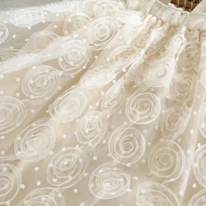 Close-up of 3D rose mesh fabric and white polka dots on infant princess dress