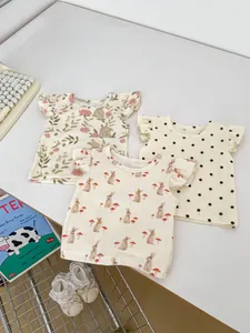 Détail de trois hauts d'été pour bébé avec imprimés lapin et manches à volants