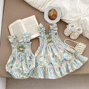 Détail du body bébé et de la robe à fleurs avec nœuds en velours et volants