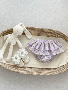 Detail of floral infant ruffled bloomer shorts with lace trim shoes and a bunny toy