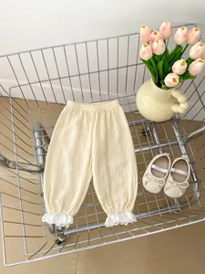 Détail du pantalon en mousseline pour bébé avec bordure en dentelle et taille élastique
