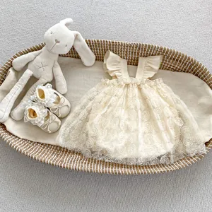 Close-up of baby girl lace floral princess romper dress and matching soft shoes