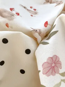 Détail du tissu en coton doux pour bébé avec motifs lapin, fleurs et pois élégants
