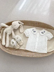 Detailaufnahme des Baby Mädchen Baumwollhemds mit Blumenstickerei am Bubikragen