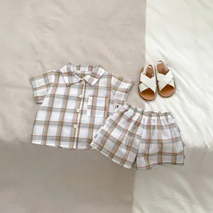 Detailed flat lay of boys plaid summer set with button shirt and elastic waist shorts