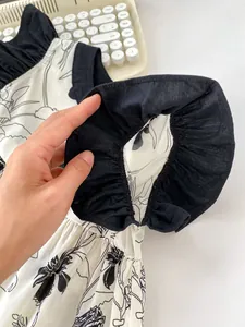 Detailed close-up of floral print fabric with black ruffled edges on summer baby clothing