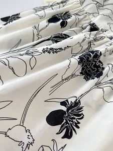 Macro detail of hand-drawn floral print on pleated woven cotton baby clothing fabric