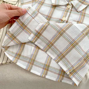 Close-up of checkered cotton shirt fabric with neat stitching and thin texture