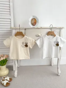 Dettaglio di t-shirt in cotone per neonati con stampa a coniglio e toni crema