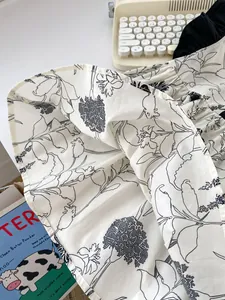 Detail of baby girl dress with black and white floral pattern on cotton-linen fabric