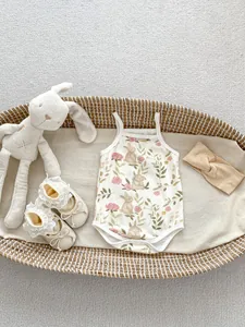 Detail of baby summer romper set with rabbit floral print, matching shoes and headband