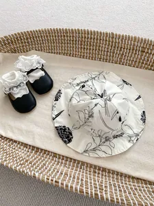 Baby Mary Jane shoes with lace socks and floral sun hat in a rustic woven basket