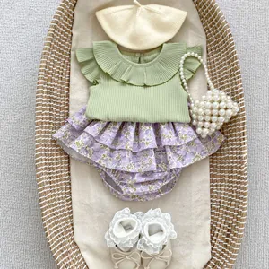 Baby girl summer set with green ruffle collar top and purple floral bodysuit in a basket