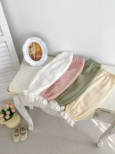 Gros plan de bloomers pour tout-petits en blanc, rose, vert et beige avec bordure dentelle