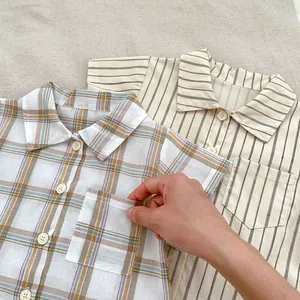 Detail of baby boys cotton plaid and striped shirt with front pocket and buttons