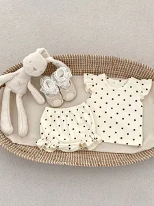 Détail de l'ensemble d'été pour bébé fille avec haut à pois, short et chaussures