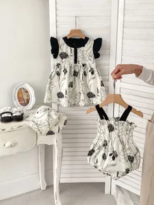 Three-piece baby girl summer set featuring floral dress, bodysuit and matching sun hat