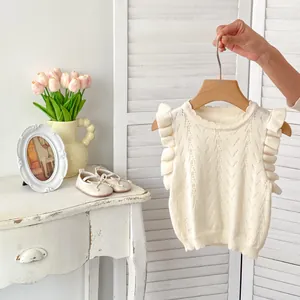 Chaleco de punto blanco para bebé con patrones calados y volantes en los hombros, elegante
