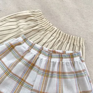 Detail of toddlers cotton shorts featuring striped and checkered patterns with elastic waist