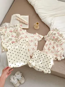 Ensembles d'été pour bébé fille avec motifs de lapins et détails à volants sur fond chaleureux