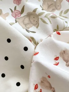 Close-up of baby romper cotton fabric with cute watercolor bunny and floral patterns