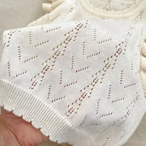 Chaleco de punto calado crema para niña con bordes ondulados y diseño transpirable