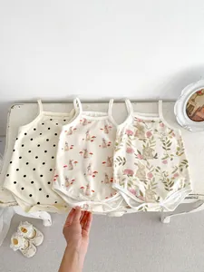 Detailed flat lay of three cotton baby bodysuits with rabbit and floral prints