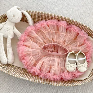 Pink tiered tulle tutu skirt with cream bow baby shoes in a cozy gift basket