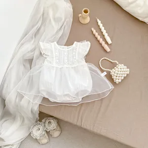 Detalle de body blanco para bebé con bordado floral y falda de tul con encaje
