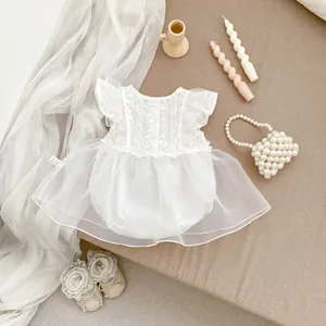Detalle del pelele de encaje blanco para bebé con falda de tul y zapatos de lazo