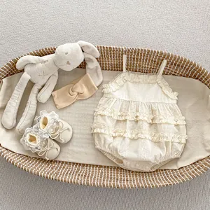 Flat lay of lace baby romper set with matching shoes and headband in a woven cradle