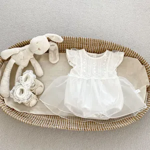 Mameluco de encaje blanco para bebé con bordado floral y zapatos a juego en cesta