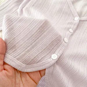 Dettaglio del cardigan estivo per neonato in maglia a coste traspirante con bottone