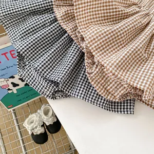Detailed view of baby plaid rompers with metal snaps for easy diaper changes