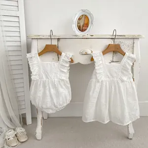 Detail of white cotton eyelet baby romper and dress with lace shoes in vintage style