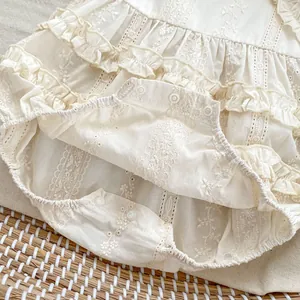 Detail of baby floral embroidery bodysuit with ruffle layers and snap button closure