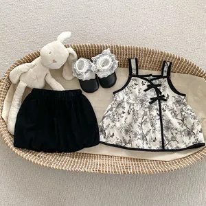 Detail of floral baby summer set with ribbon bow and matching lace shoes in basket