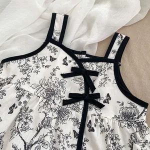 Baby girl summer romper with vintage black floral print and ribbon bows on white cotton