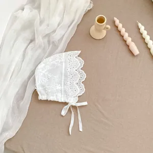 Exquisite white lace baby sun hat with floral embroidery and adjustable tie strap
