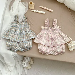 Flachbild von Baby-Mädchen-Sommerset mit Karomuster, Rüschenträgern und Knopfdetails