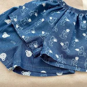 Dettaglio degli shorts in denim da bambino con elastico in vita e stampa di orsi